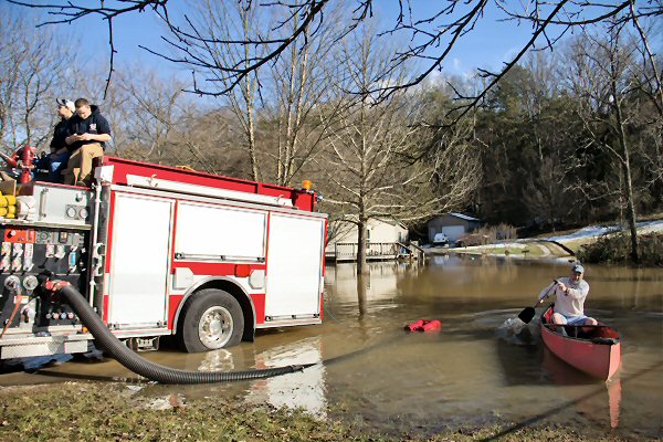 Dandridge Fire Department helping home owner after last weeks flooding - Staff Photo by Robin Archer