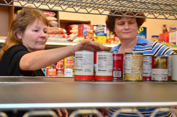 Samaritan House resident Wanda Bowles, left, assists Appalachian Outreach Director Jean-Ann Washam in the ministry’s food pantry.  Appalachian Outreach was recently chosen to receive a $20,000 grant that will be used to help grow its food pantry supply.