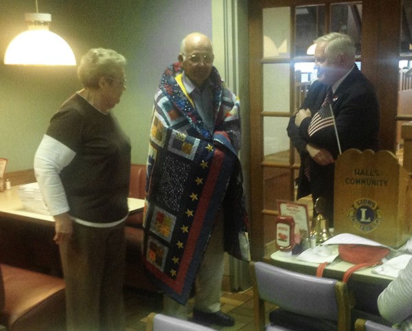 Dennis Taylor, state coodinator for Quilts of Valor presents a quilt to James England - Staff Photo by Michael Williams