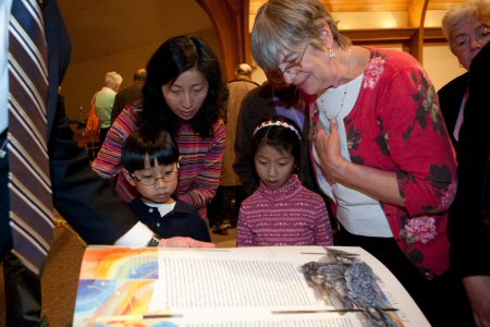 People of all ages enjoy looking at the pages of the fine art version of The Saint John's Bible.  Photo by Mike Nyman
