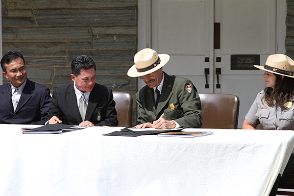 Park Superintendents Krissada Homsud and Dale Ditmanson sign Sister Park Arrangement witnessed by Apicha Yoosomboon, Inspector General's Office Department of National Parks, Wildlife, and Plant Conservation and Dana Soehn, Park Management Assistant - Staff Photo by Jeff Depew
