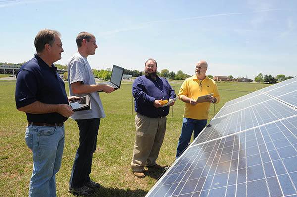 At far right, Ken Parks, director of Walters State’s Clean Energy Program, discusses the operation of solar panels with, from left, students John Pollock, Terrell Trueblood and Tim Redmond. Walters State will be offering Clean Energy Technology courses through College Express, a program tailored for working adults.