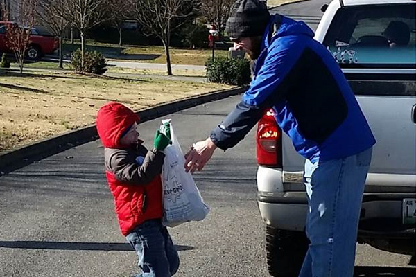 Jack Hampton, Tiger Cub hand CubMaster Chad Thompson bags of food collected for the Dandridge Ministerial Association’s Food Pantry.