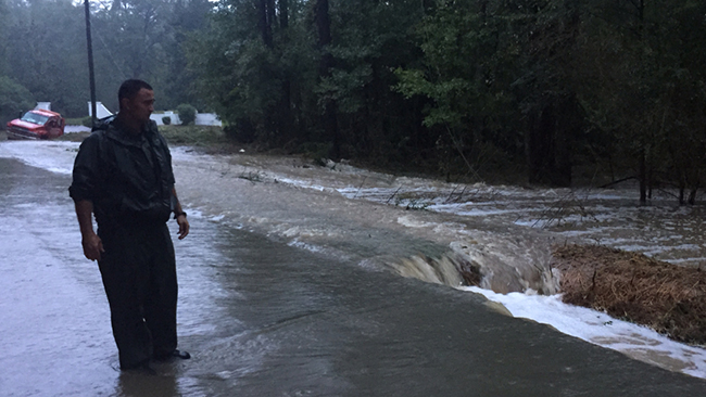 TWRA Sgt. Roy Smith gazes at turbulent water washing through the streets of Colombia.