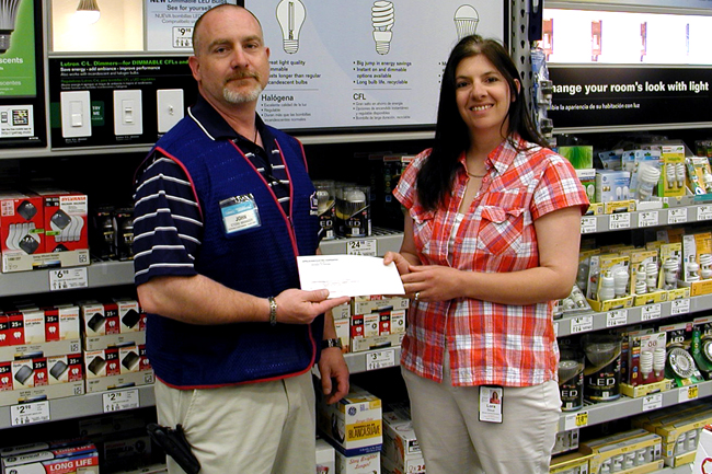 AEC Member Service representative, Lora Stout presents an incentive check to Lowes for efficiency measures installed at their Jefferson City location.