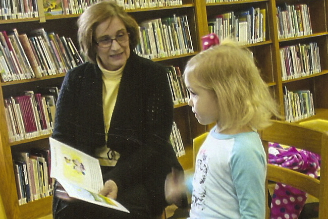 Glenda Jones, Library director, reads to one of the young patronsPhoto Submitted