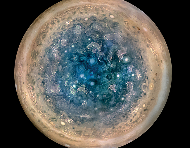 This image shows Jupiter’s south pole, as seen by NASA’s Juno spacecraft from an altitude of 32,000 miles (52,000 kilometers). The oval features are cyclones, up to 600 miles (1,000 kilometers) in diameter. Multiple images taken with the JunoCam instrument on three separate orbits were combined to show all areas in daylight, enhanced color, and stereographic projection.Credits: NASA/JPL-Caltech/SwRI/MSSS/Betsy Asher Hall/Gervasio Robles
